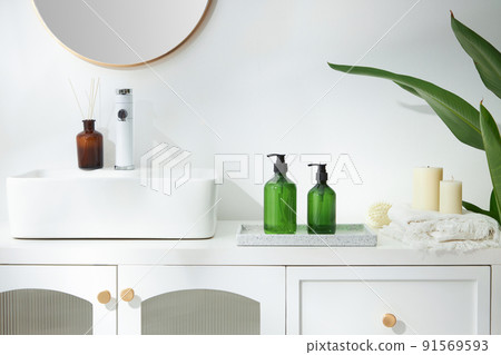 Cosmetics product and cotton towels, cottons pad with green plant on white table inside a bathroom background ceramic. 91569593