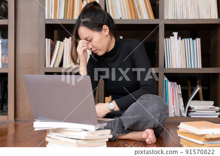 Student Studying Hard Exam, Sleeping on Books Read in Library. Exhausted woman having a headache. 91570822
