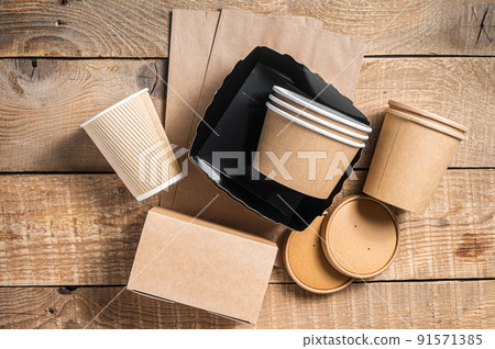 Disposable paper tableware. Eco friendly Recycling set of paper cups, dishes, bag, fast food containers and cutlery. Wooden background. Top view. Copy space 91571385