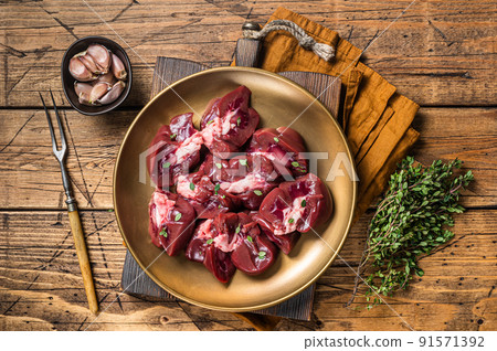 Lamb kidney, raw sliced offal on plate with thyme. Wooden background. Top view Lamb kidney, raw sliced offal on plate with thyme. Wooden background. Top view 91571392