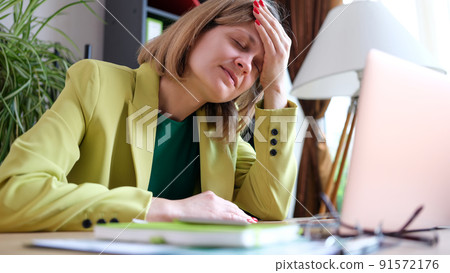 Tired businesslady putting hand to forehead and closed eyes 91572176