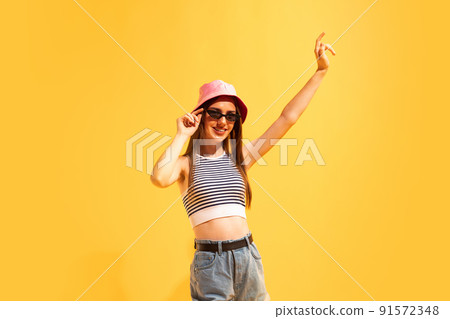 Studio shot of emotive young girl isolated on yellow color background. Concept of beauty, art, fashion, emotions, youth 91572348