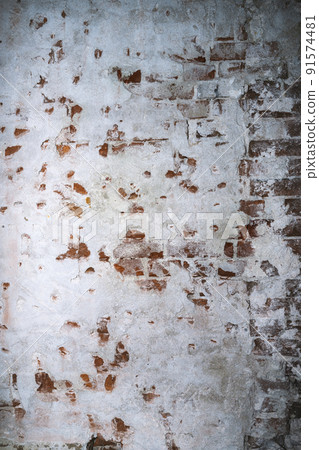 Dilapidated building facade with damaged plaster 91574481