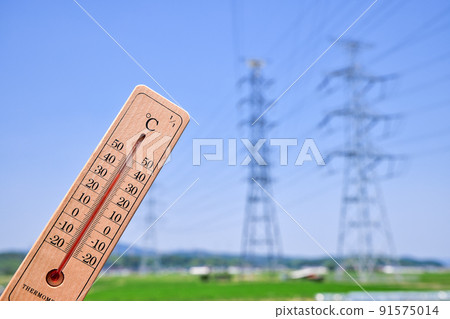 Image of a hot day: A thermometer with an outside temperature of 38 ° C and a steel tower for power transmission 91575014