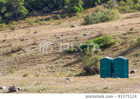 Two blue plastic cabins of dry closets in a natural park, copy space 91575124