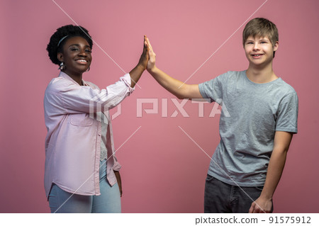 Woman and guy touching with palms looking at camera 91575912