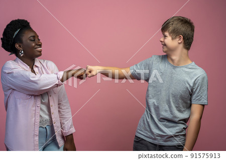 Guy and woman standing opposite touching fist Guy and woman standing opposite touching fist 91575913