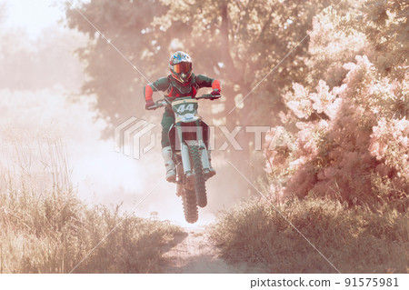 Live shot of male sportsman training on motorbike at hot summer day, outdoors. Motocross rider in action. Motocross sport Live shot of male sportsman training on motorbike at hot summer day, outdoors. Motocross rider in action. Motocross sport 91575981