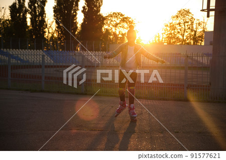 Girl riding roller skates in the park 91577621