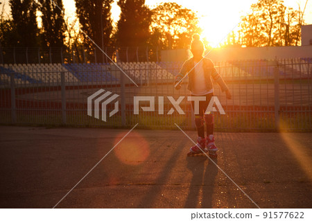Girl riding roller skates in the park 91577622