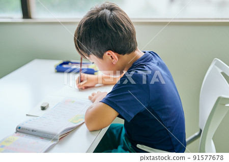 在筆記本上寫字的小學生 在筆記本上寫字的小學生 91577678