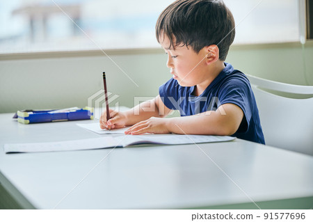 在筆記本上寫字的小學生 91577696