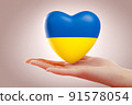 Hand holding heart painted in colors of ukrainian flag. Concept of help, support, charity and donation to Ukraine. 3D rendering 91578054