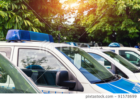 Close-up detail view of many german police van cars parked in raw on police station parking on sunny day. Civil emergency law security and traffic service vehicle in Europe Close-up detail view of many german police van cars parked in raw on police station parking on sunny day. Civil emergency law security and traffic service vehicle in Europe 91578699