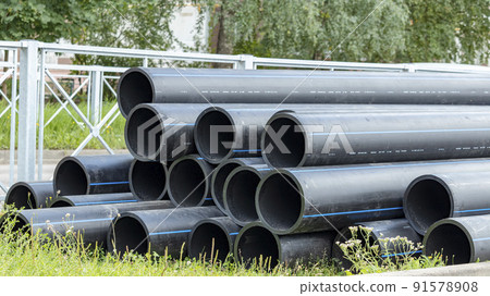 black sewer pipes on the construction site are stacked on top of each other black sewer pipes on the construction site are stacked on top of each other 91578908