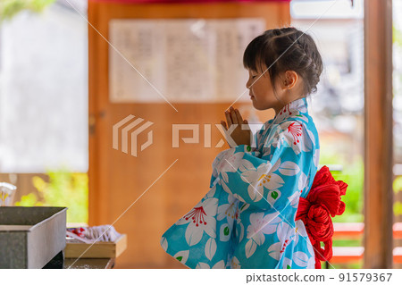 A girl in a yukata worshiping 91579367