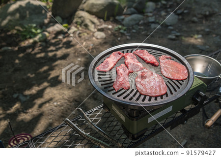 [在汽車露營地獨自露營，在烤肉盤上烤牛肉] 91579427