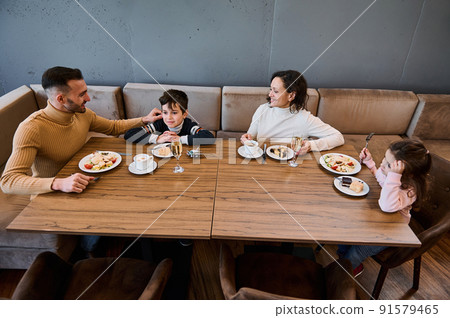 Happy Caucasian family having lunch together in a restaurant. Food and drink concept 91579465