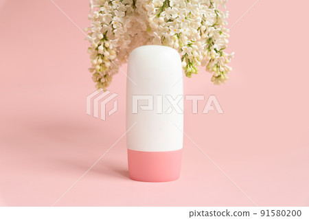 Mockup white cosmetic tube bottle with pink screw cap and white lilac flowers on pink background. Daily moisturizing cream, gel, skin care, sunscreen, moisturizer, lotion. Product branding, front view 91580200