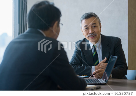 Senior business team in suits meeting in the office 91580787