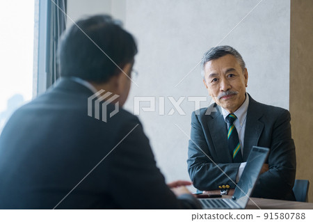 Senior business team in suits meeting in the office 91580788