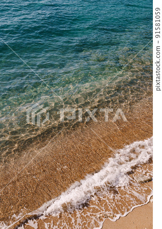 Sea waves on the background of a sandy beach. Top view 91581059