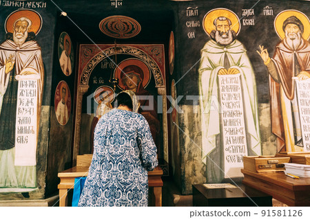 Woman prays in front of the icons in the Ostrog monastery. Montenegro 91581126