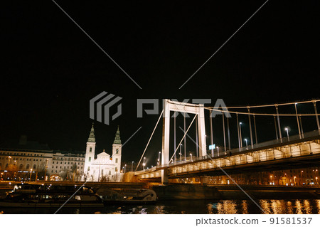 Night illumination of the Elizabethan Bridge in Budapest against the background of buildings 91581537
