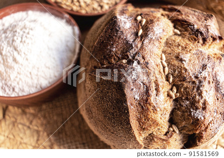 Round bread close-up. Freshly baked sourdough bread with a golden crust. Baker shop context with delicious bread. 91581569