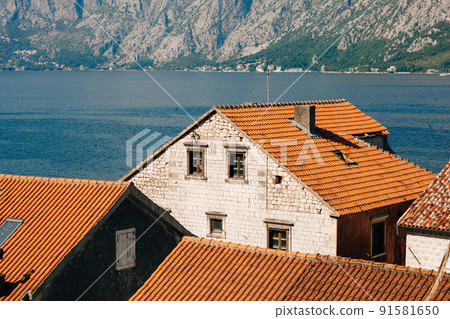 Old stone houses with red tiled roofs on the shore of the Kotor Bay Old stone houses with red tiled roofs on the shore of the Kotor Bay 91581650