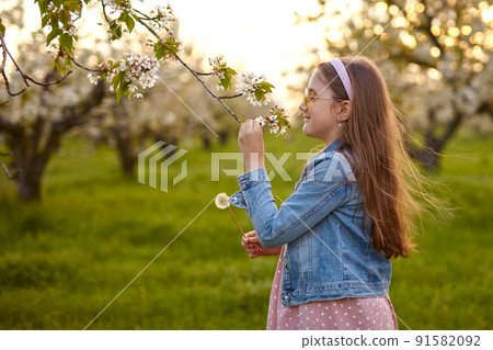 Little happy child girl in beautiful spring garden. 91582092