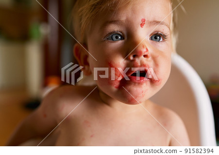 Child with a messy face opens his mouth. Close-up 91582394