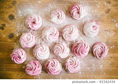 Pink marshmallow with powdered sugar on the table Pink marshmallow with powdered sugar on the table 91582434