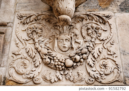 Woman face with floral patterns on the stone slab of the Duomo facade. Milan, Italy 91582792