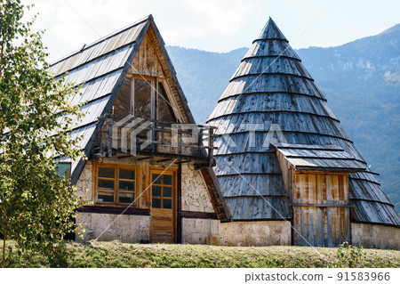 Triangular and conical houses with wooden roofs against the backdrop of mountains. Montenegro Triangular and conical houses with wooden roofs against the backdrop of mountains. Montenegro 91583966