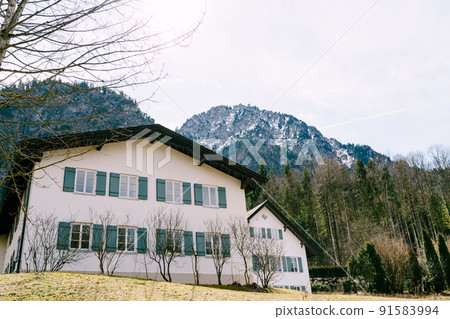House with shutters surrounded by forest in the village of Oberammergau 91583994