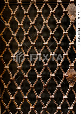 Forged lattice of the monastery type. Close-up Forged lattice of the monastery type. Close-up 91584002