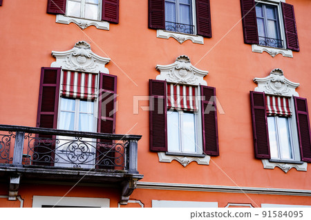 Ancient building with stucco on the windows and shutters. Menaggio, Como, Italy Ancient building with stucco on the windows and shutters. Menaggio, Como, Italy 91584095