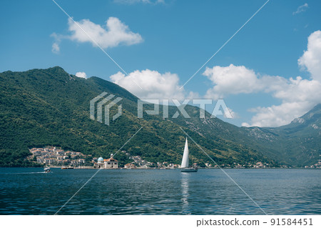 Sailboat sails along the bay against the backdrop of the island of Gospa od Skrpjela. Montenegro 91584451