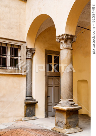 Columns with stucco in the arched corridor of an old building Columns with stucco in the arched corridor of an old building 91584498