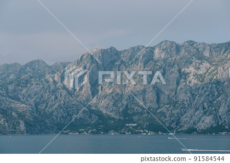 Boats sail on the Bay of Kotor against the backdrop of a mountain range 91584544