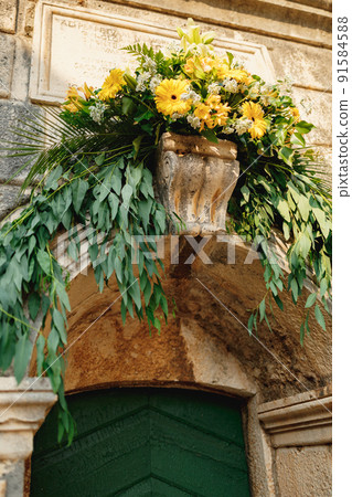 Flower-adorned entrance to the old stone church Flower-adorned entrance to the old stone church 91584588