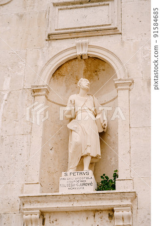 Prcanj, Montenegro - 13.07.18: Statue of St. Peter on the stone facade of the Church of the Nativity of the Virgin in Prcanj Prcanj, Montenegro - 13.07.18: Statue of St. Peter on the stone facade of the Church of the Nativity of the Virgin in Prcanj 91584685