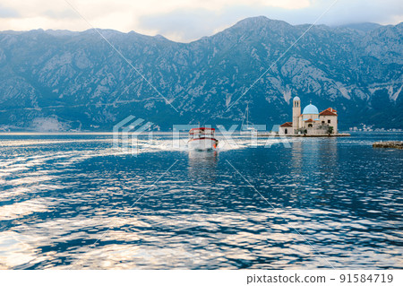 Boat sails from the island of Gospa od Skrpjela. Montenegro Boat sails from the island of Gospa od Skrpjela. Montenegro 91584719