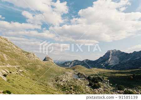 Small lake in a green valley among high mountains 91585139
