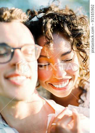 Smiling woman hugging a smiling man from behind 91585902