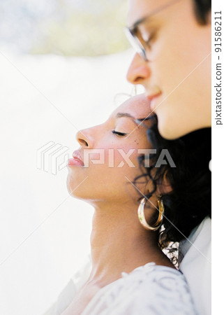 Man in glasses hugs a woman against the backdrop of a curtain in the garden 91586211