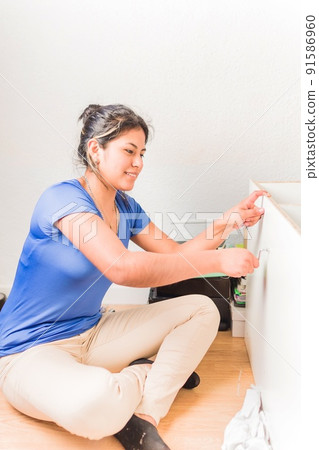 university student moving to first independent apartment. Latin young Bolivian assembly furniture university student moving to first independent apartment. Latin young Bolivian assembly furniture 91586960