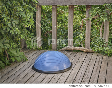Balance training ball on wooden deck Balance training ball on wooden deck 91587445