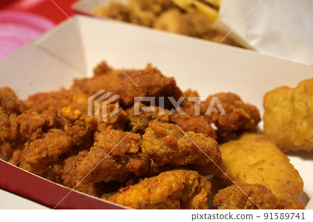 Fried breaded chicken fillet in white cardboard box isolated on burred background 91589741